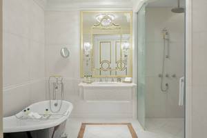 Luxuriöses Badezimmer mit Badewanne, Spiegel, Dusche und Waschbecken im Raffles The Palm Dubai.