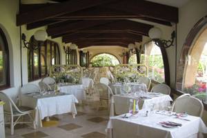 Restaurant des Baia Di Nora Hotels mit gedeckten Tischen und Blumenarrangements.