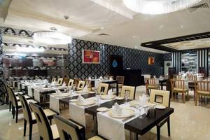 Innenansicht des Restaurants im Orange County Belek - Family Concept Hotel mit gedeckten Tischen und Stühlen.