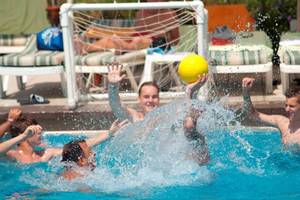 Gruppe junge Leute spielen Ball im Schwimmbad Orange County Belek