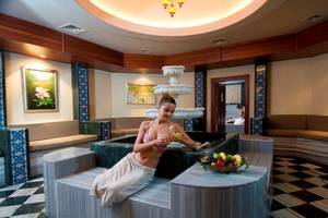 Spa-Bereich im Orange County Belek - Family Concept Hotel mit einer Frau in einem Whirlpool und einem Korb mit Früchten.