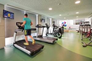 Fitnesscenter im Melissi Beach Hotel & Spa mit einem Mann, der auf einem Laufband läuft.