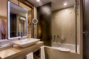 Badezimmer des Aegean Pearl Hotels mit Waschbecken, Spiegel und Badewanne