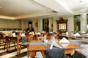 Innenansicht des Restaurants im Aegean Pearl Hotel mit gedeckten Tischen und Stühlen.
