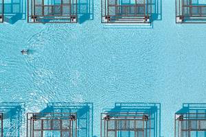 Obersicht des Amirandes Grecotel Boutique Resort Schwimmbads mit einer Person im Wasser.