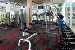 Fitness-Center im Kantary Beach Hotel mit verschiedenen Geräten und großen Fenstern.