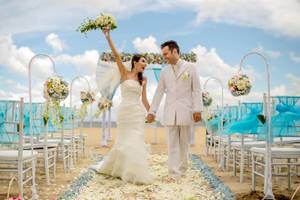 Hochzeitspaar im Mercure Resort Sanur, das auf dem Strandweg geht