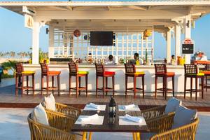 Terrassenbar des Juweira Boutique Hotels mit Stühlen und Tischen im Freien.
