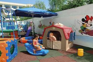 Zwei Kinder spielen auf einem Spielplatz im Freien im Anonymous Beach Hotel.