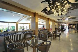 Lobby des Seaden Corolla Hotels mit gemusterten Sofas, Tischen und Kronleuchtern.