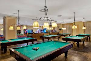 Billardsaal im Kremlin Palace Hotel mit mehreren Billardtischen und Spielgeräten.