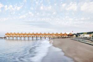 Außenbereich des Kremlin Palace Hotels mit Sonnenschirmen und Liegestühlen am Strand
