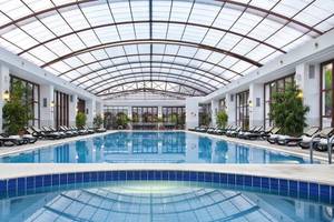 Innenpool des Kremlin Palace Hotels mit Lounge-Liegestühlen und Glasdach