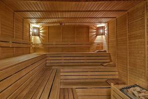 Innenansicht der Sauna im Kremlin Palace Hotel mit hölzernen Bänken und Beleuchtung.