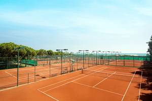 Tennisplatz im Freien mit Blick auf das Meer und Bäume am Kremlin Palace Hotel.