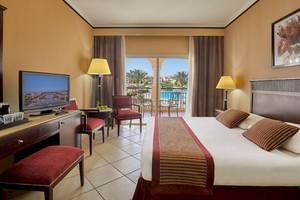 Hotelzimmer im Jaz Mirabel Beach mit Poolblick, Fernseher, und bequemen Möbeln.