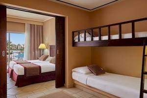 Doppelzimmer im Jaz Mirabel Beach Hotel mit zwei Betten und einem Etagenbett.