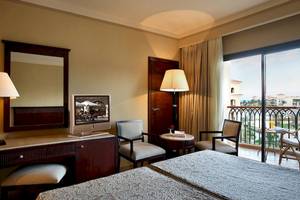 Doppelzimmer im Jaz Mirabel Beach Hotel mit zwei Betten, Schreibtisch, Fernseher und Balkon.