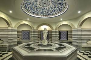 Innenbereich der Sauna im Sunrise Queen Luxury Resort & Spa mit einer zentralen Marmorstatue und dekorativen Wandfliesen.