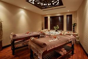 Saunaraum im Sunrise Queen Luxury Hotel mit zwei Massagetischen und einer Badewanne.