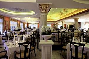 Innenansicht des Restaurants im Bahia Principe Luxury Esmeralda Hotel mit gedeckten Tischen, eleganten Stühlen und dekorativen Säulen.