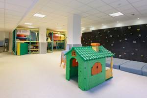 Spielbereich für Kinder im Leonardo Royal Hotel Ibiza Santa Eulalia mit Kletterwand, Spielhaus und Spielzeug.