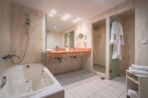 Badezimmer im Galaxy Beach Resort mit Badewanne, Dusche und Waschbecken.