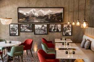 Innenbereich des LUX Grand Gaube Resort & Villas mit Tisch, Stühlen und einer Bilderwand.