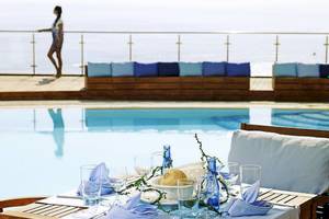 Tisch mit blauen Kissen und Gläsern neben dem Pool im Esperos Village Blue & Spa.