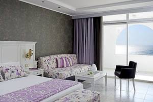 Doppelzimmer mit Meerblick im Esperos Village Blue & Spa mit luxuriösem Interieur, Kingsize-Bett, Wohnzimmerbereich und Balkon mit Meersicht.