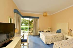 Doppelzimmer im Iberostar Tainos Hotel mit zwei Betten, Fernseher, Schreibtisch und Balkon.