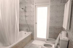Badezimmer der Villa Park, Malediven, mit Badewanne, Dusche, Toiletten und Handtüchern.