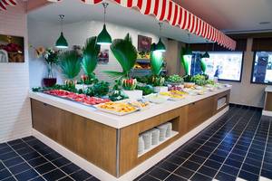 Buffet-Tisch im Belconti Resort mit verschiedenen Früchten und Gerichten.