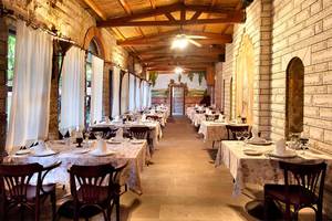Innenansicht des Restaurants im Belconti Resort mit gedeckten Tischen und Stühlen.