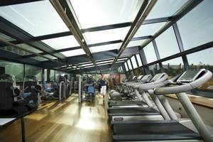Fitnessstudio im Gewölbe mit Laufbändern und Frau im Hintergrund