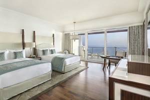 Innenansicht der Suite im Waldorf Astoria Dubai Palm Jumeirah mit zwei Betten, Meerblick und modernem Interieur.