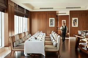 Speisesaal im Waldorf Astoria Dubai Palm Jumeirah mit Holzwänden und großen Fenstern.