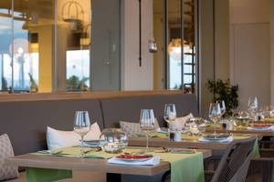 Innenansicht des Capo Bay Hotel Restaurants mit gedeckten Tischen und Gläsern.