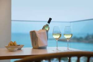 Tisch mit zwei Weingläsern und einer Flasche Wein mit Meerblick im Capo Bay Hotel.