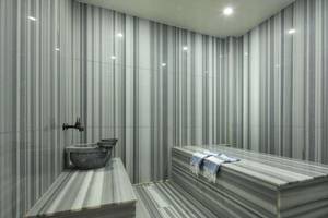 Innenraum des Dampfbads im Magic Life Belek Hotel mit Marmorwänden und einer Badewanne.