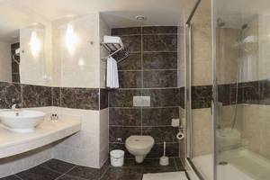 Badezimmer im Magic Life Belek Hotel mit schwarz-weißen Fliesen und einer Dusche.