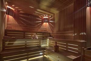 Sauna im Magic Life Belek Hotel mit Holzbänken, Handtüchern und Beleuchtung.