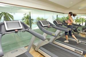 Frau im Avila Beach Hotel Fitnessraum auf einem Laufband