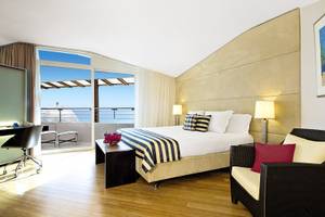 Innenansicht eines Zimmers im Avila Beach Hotel mit Meerblick und Balkon.
