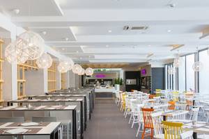 Innenansicht des Restaurants im Abora Catarina Hotel von Lopesan Hotels, mit weißen und bunten Stühlen und Tischen