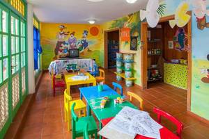 Innenansicht des Kinderzimmers im Abora Catarina Hotel mit bunten Tischen und Stühlen.