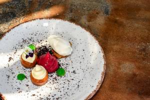 Dessertsteller im Ambassador Aegean Luxury Hotel & Suites mit drei süßen Leckereien und Dekor