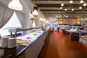 Restaurant im Acrotel Athena Pallas Hotel mit Speisenbuffet und roten Bodenfliesen.