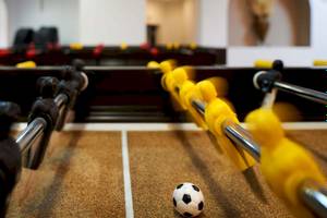 Foosballtisch im Acrotel Athena Pallas Hotel mit Ball und Spielern.