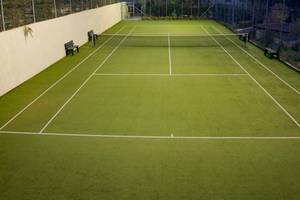 Tennisplatz des Hotels Acrotel Athena Pallas mit grünem Kunstrasen und weißen Linien.